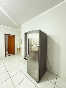 a stainless steel refrigerator sitting in a room at Apartamento Super Conforto in Naviraí