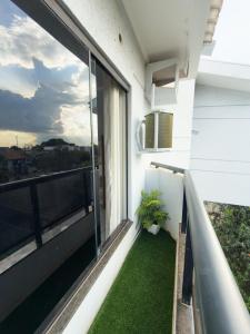 a balcony with a plant on the side of a building at Apartamento Super Conforto in Naviraí