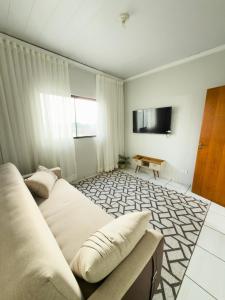 a room with two beds and a table in it at Apartamento Super Conforto in Naviraí