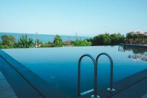 a swimming pool with two handles in the water at Lemon Suites & Restaurant in Korucuk