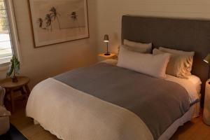 a bedroom with a large bed with palm trees on it at 28 Degrees Byron Bay - Adults Only in Byron Bay