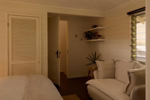 a bedroom with a bed and a couch and a window at 28 Degrees Byron Bay - Adults Only in Byron Bay +106 photos