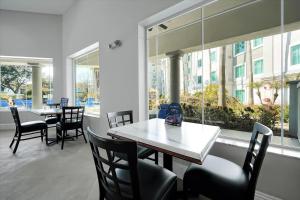 a dining room with tables and chairs and a large window at Pool View DisneyUniversalFree ShuttleParking in Orlando