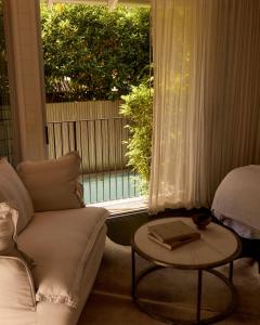 a living room with a couch and a table and a window at 28 Degrees Byron Bay - Adults Only in Byron Bay