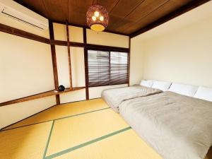 two beds in a room with a window at Goryokaku rental house SAKURA in Hakodate