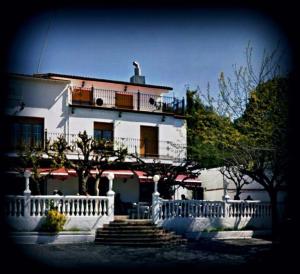 a white house with a white fence in front of it at Hostal del Carmen in Terrassa