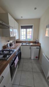 a small kitchen with a stove and a sink at Wishart Drive in Curborough