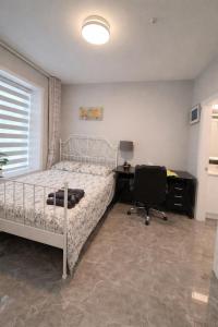 a bedroom with a bed and a desk and a chair at Private Suite in a Friendly Shared Home in Vancouver
