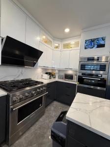 a kitchen with white cabinets and a stove top oven at Private Suite in a Friendly Shared Home in Vancouver +17 photos