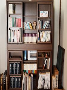 a book shelf filled with lots of books at ゲストハウス豆まめ - Guesthouse Mamemame in Matsumoto