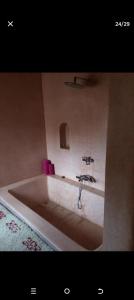 a bath tub with two faucets in a bathroom at Kasbah des roses in Aït Saïd +51 photos