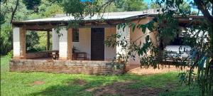 a house with a porch with a patio at Cabaña Familiar con arroyo sobre Ruta 12 II in Santa Ana