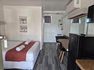 a small hotel room with a bed and a desk at Ben Hall Motor Inn in Forbes