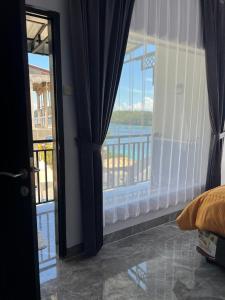 a bedroom with a balcony with a view of the water at Teupin Layeu Hotel in Iboih +142 photos