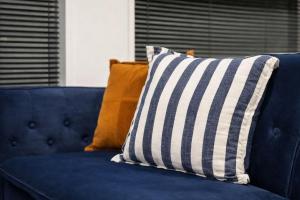 a blue couch with three pillows on it at Fitzgerald Focus - Your 1BR Urban Oasis in Christchurch