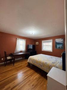 a bedroom with a bed and a desk and a bed and a table at Downtown Halifax suites in Halifax