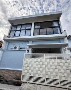 a white house with a fence in front of it at Villa Manis in Denpasar