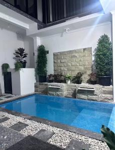 a swimming pool in a house with plants at Villa Manis in Denpasar