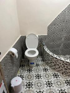 a small bathroom with a toilet and a tub at Riad Dar khadija in Taroudant