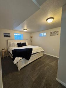 a bedroom with a large white bed with black pillows at Cozy Apt in Downtown Logan in Logan +2 photos