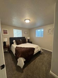 a bedroom with a large bed and two windows at Cozy Apt in Downtown Logan in Logan