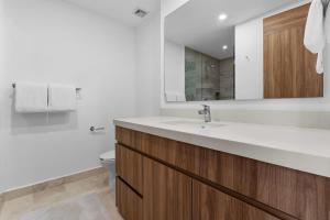 a bathroom with a sink and a toilet and a mirror at Casa Corazon at Harbor 171 North Tower in Puerto Vallarta +34 photos