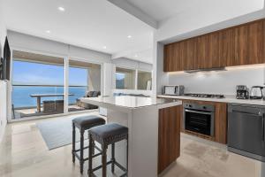 a kitchen with a counter and a view of the ocean at Casa Corazon at Harbor 171 North Tower in Puerto Vallarta