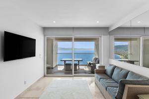 a living room with a couch and a tv and a table at Casa Corazon at Harbor 171 North Tower in Puerto Vallarta