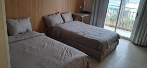 a hotel room with two beds and a window at Elim Hotel in Neiafu