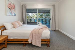a bedroom with a large bed and a window at Billie's on Smiths in Smiths Lake