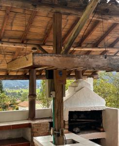 an outdoor pizza oven with a wooden roof at Cabaña Turistica Tunwacogua in Nobsa