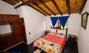 a bedroom with a bed with a red comforter at Cabaña Turistica Tunwacogua in Nobsa