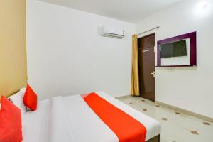 a bedroom with a bed and a tv on the wall at Hotel O by OYO Olive in Rohtak +19 photos