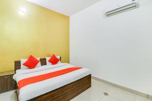 a bedroom with a bed with red pillows at Hotel O by OYO Olive in Rohtak