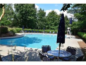 a table with chairs and an umbrella next to a pool at Southern Charmer in Stone Mountain