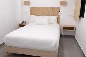 a bedroom with a large bed with white sheets and pillows at Central Budget Room Panama in Panama City