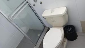 a bathroom with a toilet and a glass shower at Central Budget Room Panama in Panama City