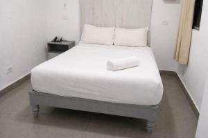 a bed with a roll on top of it in a room at Central Budget Room Panama in Panama City