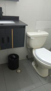 a bathroom with a white toilet and a sink at Central Budget Room Panama in Panama City
