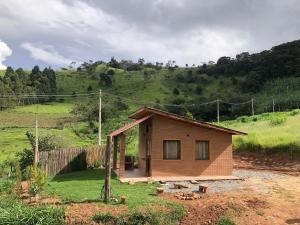 a small house in the middle of a field at Refúgio Rodreipe II in São Bento do Sapucaí