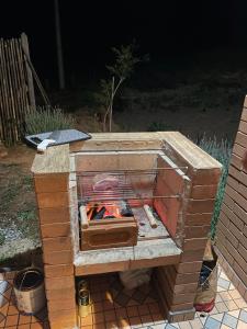 a brick oven with a fire inside of it at Refúgio Rodreipe II in São Bento do Sapucaí