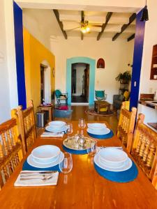 a wooden table with plates and wine glasses on it at Casa Adobe Balcony Breathtaking Cathedral Views in Taxco de Alarcón