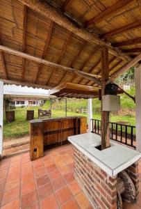 an outdoor kitchen under a wooden roof on a patio at Cabaña Turistica Tunwacogua in Nobsa