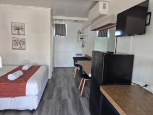 a small hotel room with a bed and a desk at Ben Hall Motor Inn in Forbes