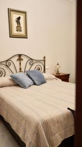 a bedroom with a bed with two pillows on it at Al ladito de Sevilla in Bormujos