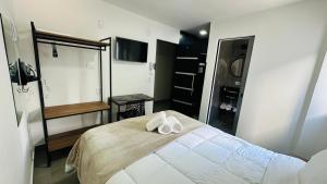 a bedroom with a bed with two towels on it at Chacara Stay in São Paulo