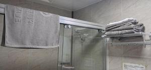 a shower in a bathroom with towels on a rack at Elim Hotel in Neiafu
