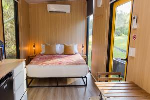 a bedroom with a bed in a tiny house at Dreamseed Cabin by Tiny Away in Yandina +23 photos