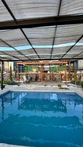 a large swimming pool under a large roof at Cabañas aldebaran cienega redonda in Hechicera