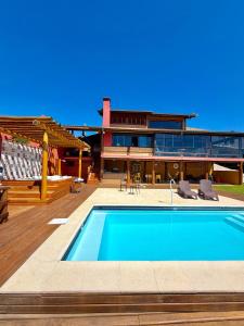 a swimming pool in front of a house at Mirantes Paraibuna - Casa Vermelha in Paraibuna